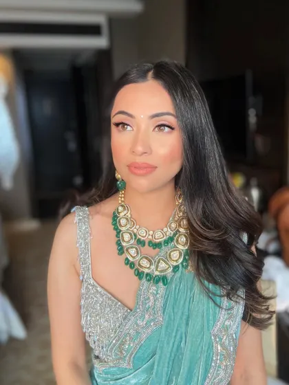 This angle highlights the beautiful glow on her skin and the way the makeup complements her emerald jewelry.