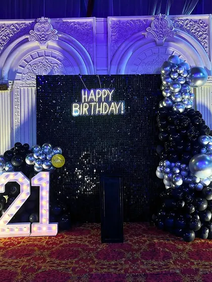 A cool and edgy 21st birthday party. The black sequin backdrop, "Happy Birthday" neon sign, and a dramatic black and silver balloon arrangement created the perfect club-like vibe.