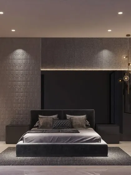 A moody and sophisticated bedroom design. The dark color palette, textured wall panels, and strategic lighting create an intimate and luxurious retreat, complemented by abstract art and metallic decor.