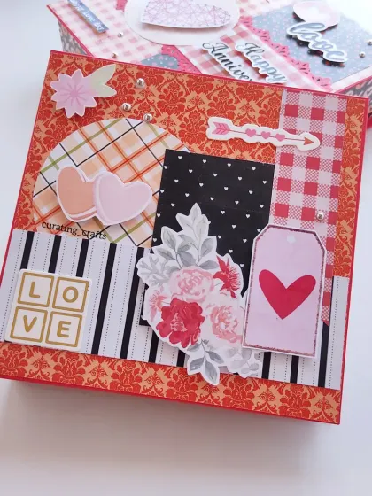 An anniversary-themed scrapbook with a bold red and black color palette. The "LOVE" letters and heart details make it a romantic and heartfelt gift for a special couple.