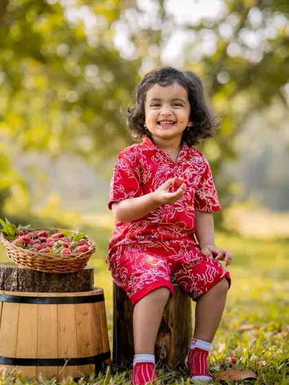 A happy boy with his basket of strawberries. Outdoor sessions allow for natural movement and genuine expressions.