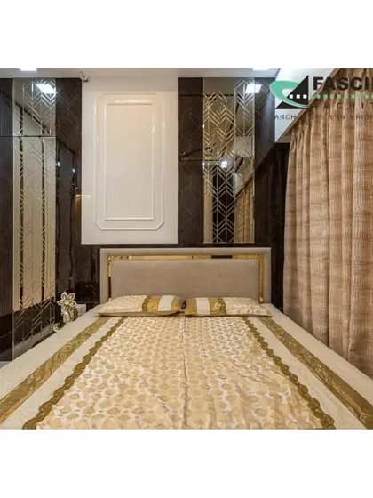 A bedroom at Lodha Belair with a bold design featuring dark marble-like panels and gold accents. The full-length mirrors on the wardrobe create an illusion of a larger, more opulent space.