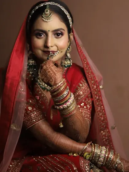 A classic bridal pose. The makeup is soft yet defined, with a focus on glowing skin and beautifully shaped lips, ensuring she looks perfect in her wedding photos.