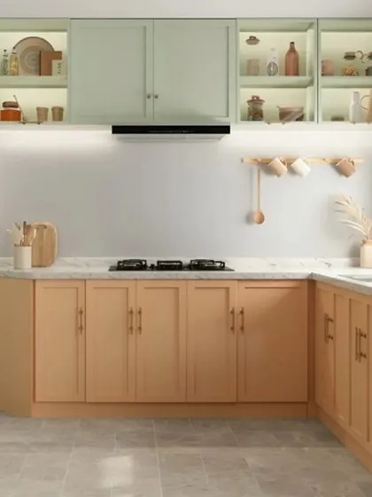 A charming pastel-themed modular kitchen with mint green upper cabinets and peach-toned lower cabinets. The in-cabinet lighting creates a lovely display effect, while the white marble countertop keeps the space bright.