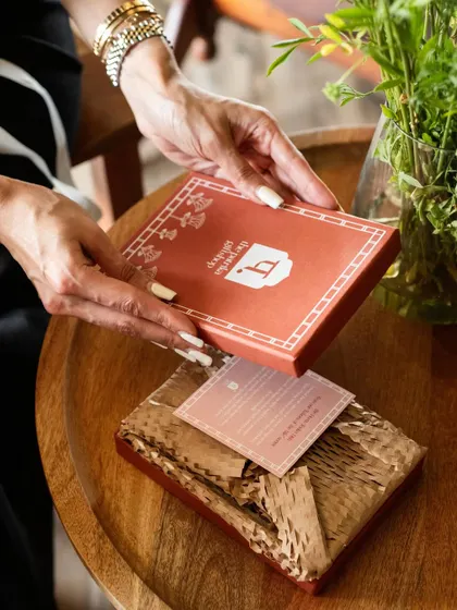 The simple act of unboxing a thoughtful gift. This lifestyle product shot for Patrika Gift Shop captures that intimate moment, showing how a product lives and breathes in the hands of the person it's meant for.