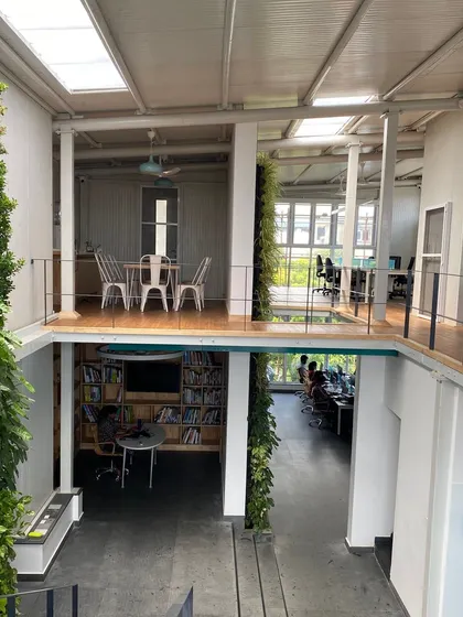 The heart of our studio, featuring a library, workstations, and a large green wall. This image captures the essence of our design approach: creating spaces that are functional, inspiring, and connected to nature.