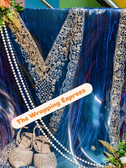 This close-up shows the details of the blue velvet suit packing, including the juttis placed at the bottom. It's all about creating a complete and thoughtful gift.