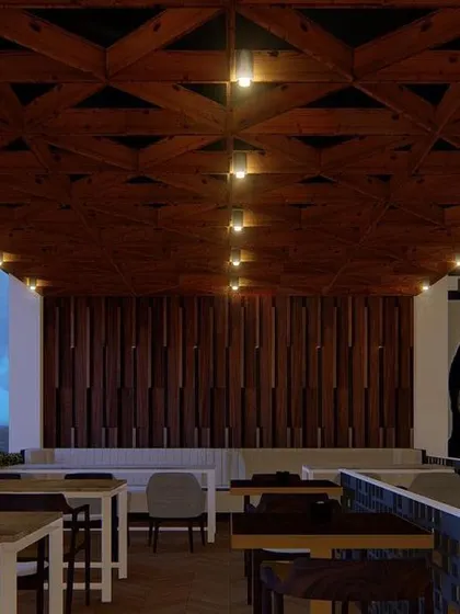 The outdoor seating area of the Nagarbhavi pub. The design includes a patterned wooden ceiling and simple, robust furniture to create a relaxed, semi-open environment.