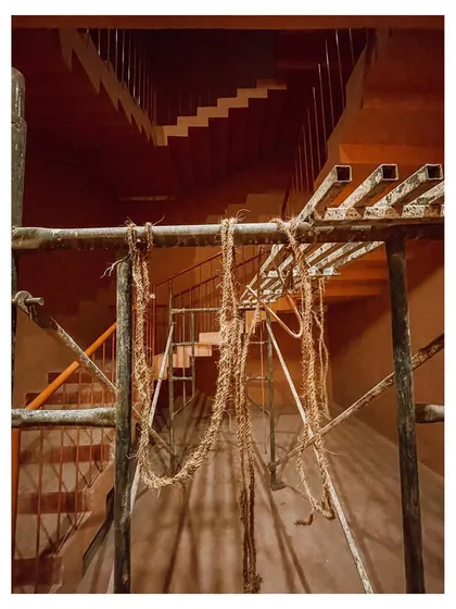 A view of the staircase during the evening, with scaffolding still in place, capturing a moment of transition from construction to completion.