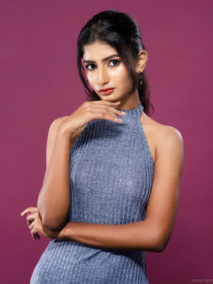 A portrait of the model in the blue halter dress, with a confident and thoughtful pose.