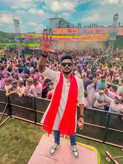 A photo from a Holi festival in 2023, with me waving to the pink-colored crowd. The energy of these events is unmatched.