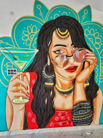 This pop art mural for Nueva Cafe features a modern desi woman with a martini. The bold colors, graphic style, and fusion of traditional jewelry with a contemporary vibe perfectly capture the cafe's energetic and stylish atmosphere.
