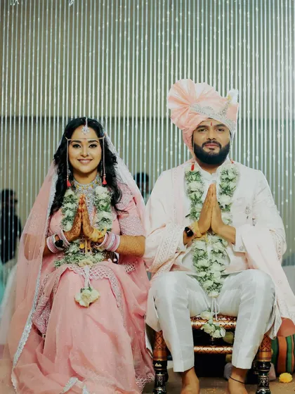 A beautiful moment from a Maharashtrian wedding. The groom, in his light pink sherwani and turban, looks serene and perfectly styled next to his bride.