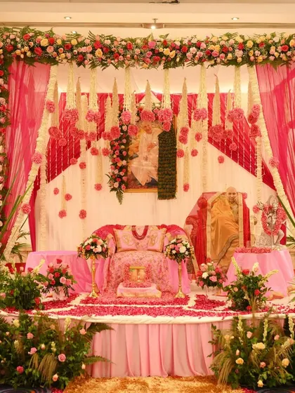 A beautiful and serene flower decoration for a Guruji Satsang. The stage is elaborately decorated with fresh flowers, creating a divine atmosphere for the spiritual gathering.
