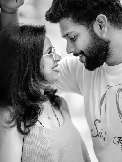 A close-up black and white shot of a couple sharing a happy, intimate moment. This type of candid portrait focuses entirely on the chemistry and connection between two people.