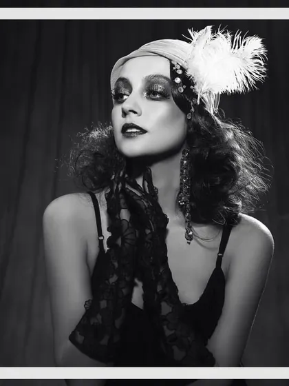 A vintage-inspired shoot channeling the glamour of the 1920s Great Gatsby era. The styling includes a feathered headpiece, dark makeup, and lace gloves to create an authentic, period-specific editorial look.