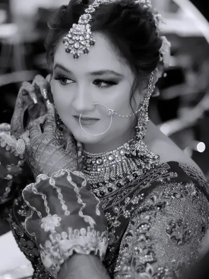 A black and white shot of the bride getting ready, seen through the reflection of a ring light. This creative framing adds a modern touch to a classic behind-the-scenes moment.