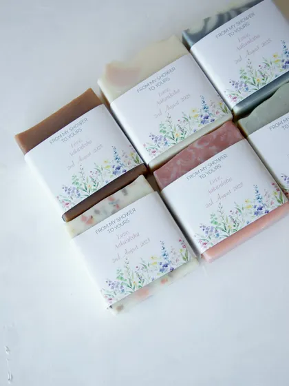 An assortment of handmade soaps with custom floral labels, created as return favors for a baby shower.