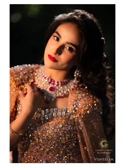 An intense and dramatic close up. The makeup is bold and confident, with a perfectly applied red lip that is the centerpiece of this glamorous look.