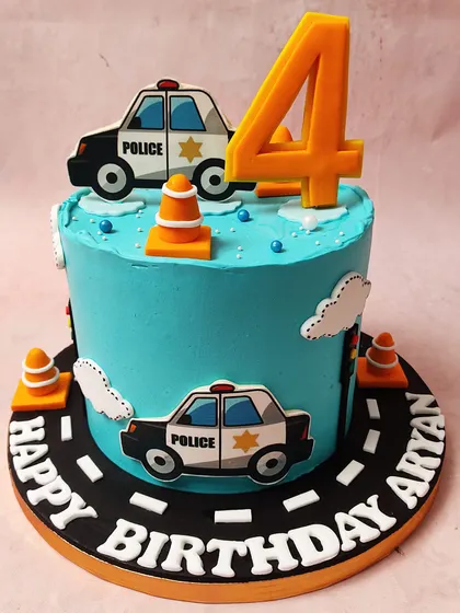 We create a fun and exciting scene with this police car themed cake. Set against a bright blue sky with fluffy clouds, cartoon police cars and traffic cones create a playful roadway around the cake, perfect for a future hero's birthday.