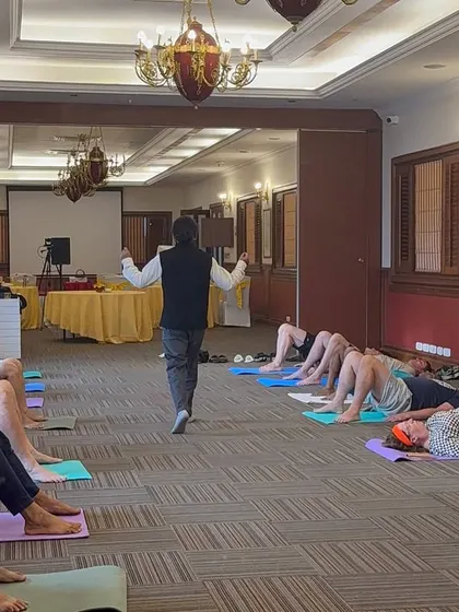 A relaxation pose being taught in a corporate setting.