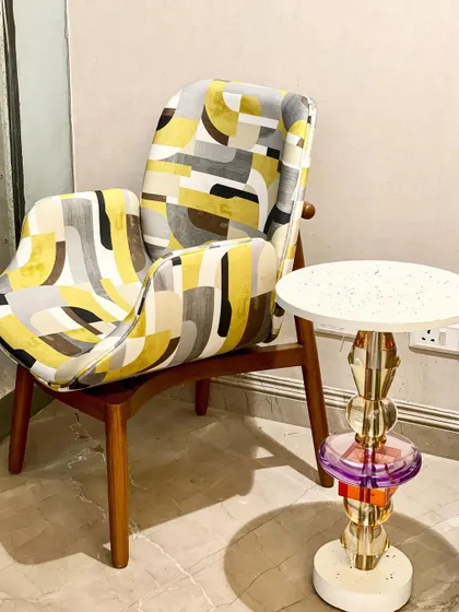 Our "Soft Serve" armchair, with its bold geometric pattern and solid teak wood frame, is a perfect statement piece. Here, we've paired it with the "Floss" accent table to create a quirky and modern corner.
