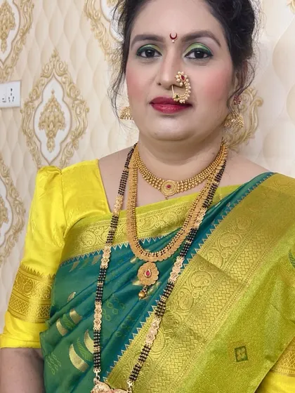 A front-facing portrait of the bride in her green saree, showing the complete makeup and jewellery.