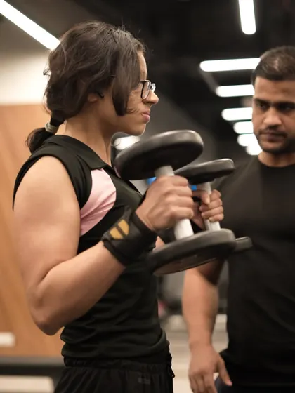 A close-up shot of a trainer providing cues for a bicep curl, demonstrating the detailed attention that defines my personal training service.
