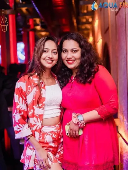 A candid shot of two friends enjoying the party, their smiles lighting up the frame.