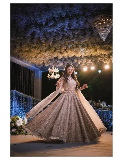 A full length shot of Mahima twirling in her engagement lehenga. The makeup is part of a complete, stunning look that is both elegant and joyful.