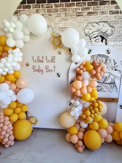 A wider shot of the "Baby Bee" themed decoration, showing the full arch of the backdrop and the playful arrangement of the balloons.