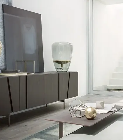 Inspired by the seventies, this sideboard features doors with engraved surfaces that create a bas-relief effect of abstract shadows. The simple volumes are supported on a light metal base, transforming the piece into a design with a strong personality.