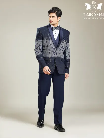 This model wears a navy blue tuxedo with a grey and blue patterned jacket, a look that says royalty never goes out of fashion.