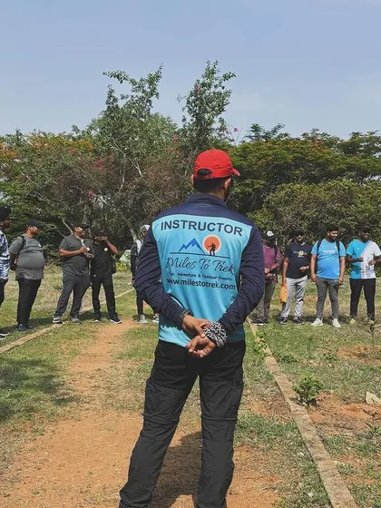 An instructor briefs the team, with his back to the camera. This perspective highlights our focus on the group and our role as facilitators of their experience.