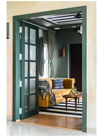 A peek into the media room from our "Colors of Goa" project, where deep green walls and a bold striped rug create a dramatic and cozy atmosphere for watching movies.