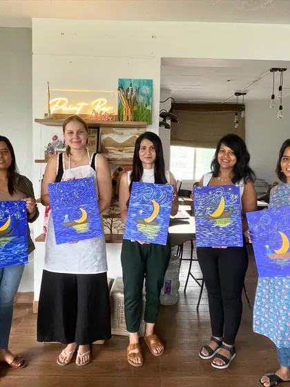 A group of women proudly displaying their Starry Night-inspired paintings. It's amazing to see everyone's unique take on a classic.