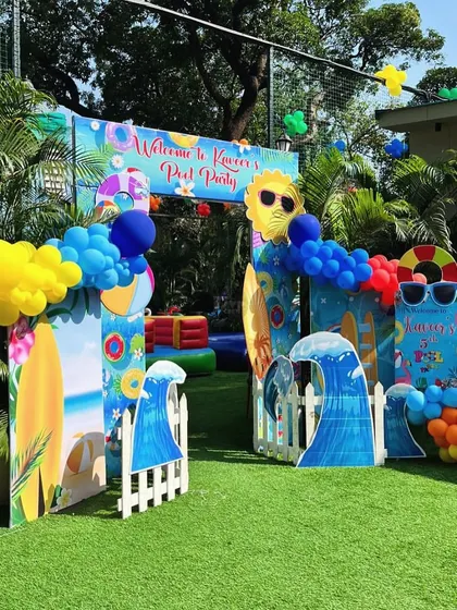 Welcome to the pool party! This entrance arch is decorated with surfboards, waves, and a sun wearing sunglasses, setting a fun, beachy vibe.