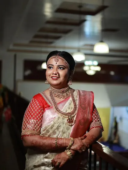 This bride is wearing a heavy, antique Kempu set, complete with a matha patti, for her Muhurtham. This is a very traditional and royal look.