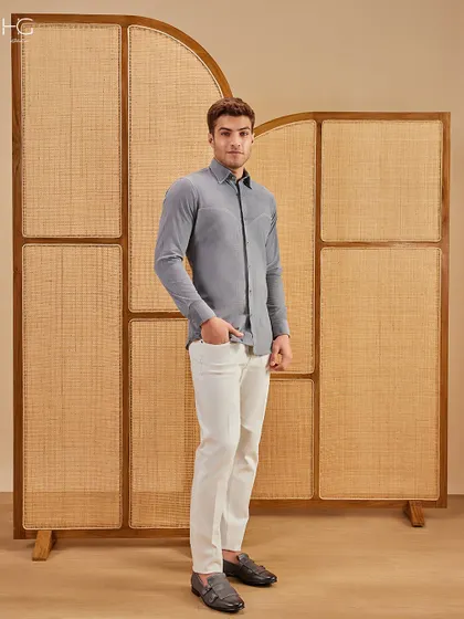 This full-length look shows the grey corduroy shirt paired with white trousers, an effortlessly stylish combination for a smart casual occasion.