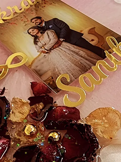 Work in progress, preserving a varmala for this beautiful couple. The photo and names are in place, and I am arranging the preserved rose petals around them.
