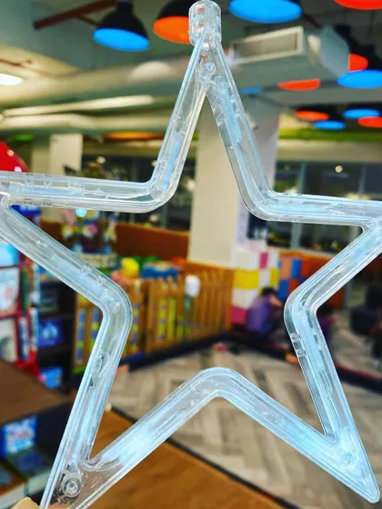 A star ornament with the play area in the background, symbolizing the festive and bright energy of the holiday season at Going Bananas.
