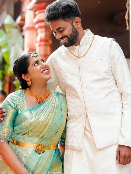 A classic portrait of a South Indian couple, their coordinated outfits and the loving gaze they share perfectly capture the essence of their engagement day.