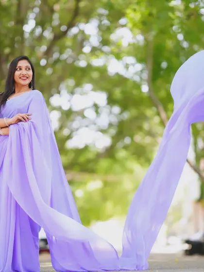 The lavender trail saree's pallu creates a stunning visual arc in this outdoor shot.