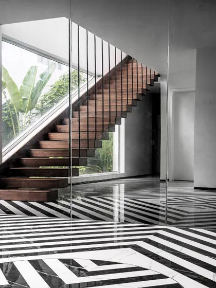 This image captures the striking geometry of the Tellado staircase and its relationship with the large glass panels. The design ensures that even transitional spaces are filled with light and connected to the outdoors.