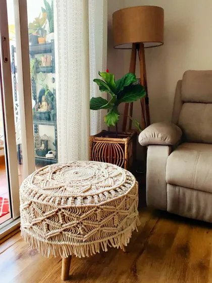 The macrame stool fits perfectly in this cozy corner of the living room.