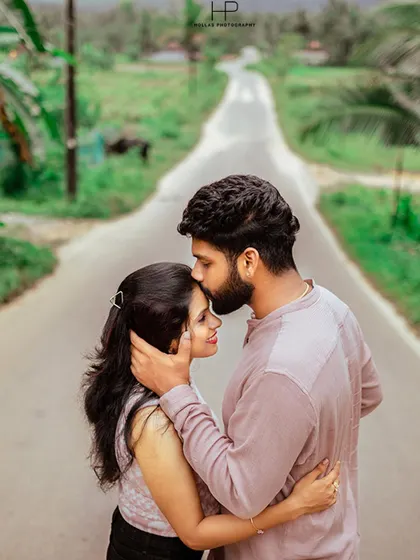 An intimate and tender moment where the groom kisses his partner's forehead on a quiet country road. This classic pose is timeless and full of emotion.