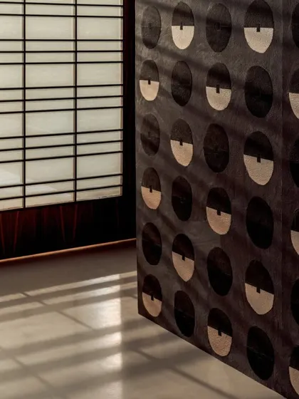 The 'Royal Emblème' wallcovering seen against a traditional Japanese shoji screen, emphasizing the design's blend of modern graphics and traditional materials.