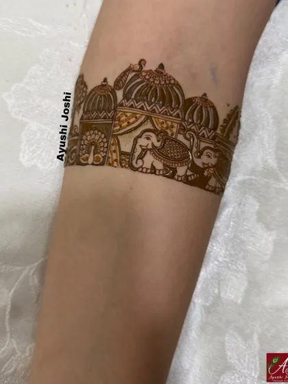 A bridal arm band featuring a procession of elephants under a palace archway.