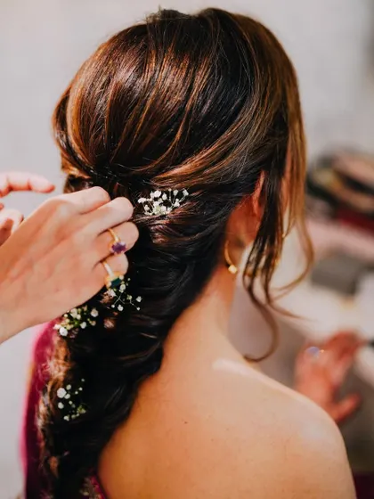 A look at the soft, romantic hairstyle we created for Deepali's Haldi. A textured braid with delicate baby's breath is always a beautiful choice.