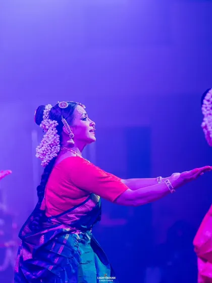 A side profile of a dancer lost in the moment of performance. The stage lights create a beautiful silhouette, emphasizing her expressive form.
